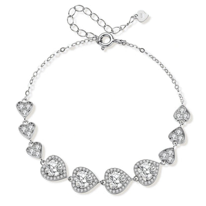 Colette Heart Moissanite Bracelet, linked heart stations with four round moissanites in pavé halos on a fine chain, laid in a circle showing the spring-ring clasp and extender