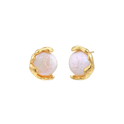 Gold earrings with pearl-like centers on a white background