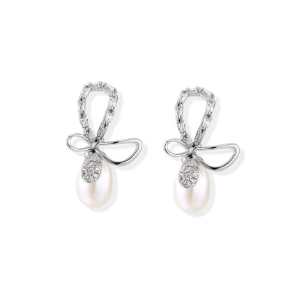 Bettina Bow Pearl Drops, pair of bow and pearl drop earrings, front view at a slight angle