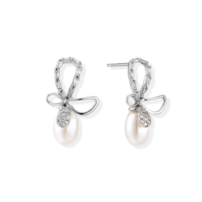 Bettina Bow Pearl Drops, pair of rhodium sterling silver bow earrings, one bow loop set with clear stones and the other polished, each with a freshwater pearl drop, front view
