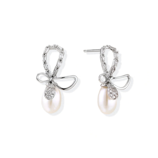 Bettina Bow Pearl Drops, pair of rhodium sterling silver bow earrings, one bow loop set with clear stones and the other polished, each with a freshwater pearl drop, front view