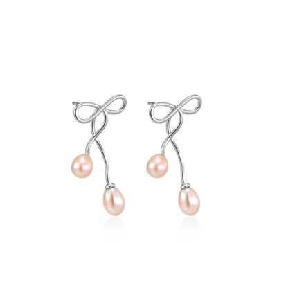Nell Bow Pearl Earrings, pair angled to show the looped wire bow and pearl stems