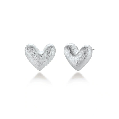Hazel Silver Heart Studs, pair of brushed silver puffed heart stud earrings, one front-on and one turned to show the post
