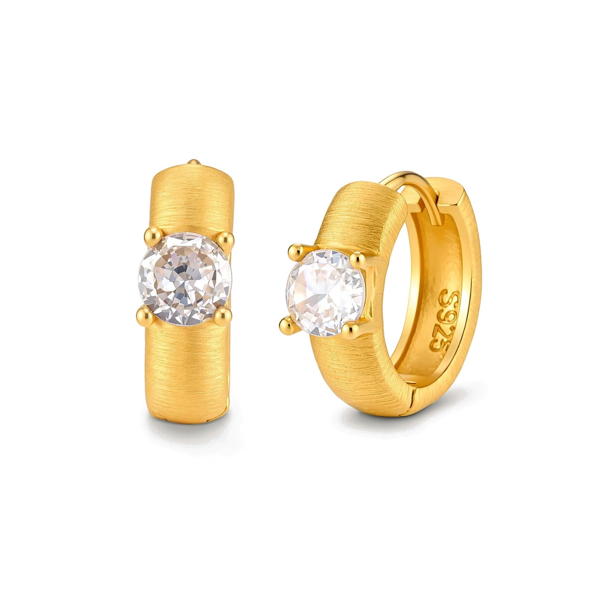 Juno Solitaire Huggies, pair of brushed gold huggie hoops, one seen front-on with a four-prong cubic zirconia, one angled showing the S925 stamp inside the hoop