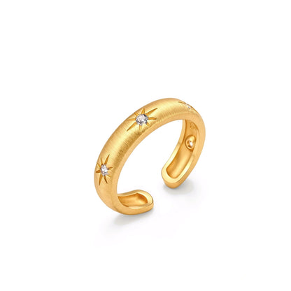 Astra Cuff Ring, brushed gold open cuff ring standing upright, angled view showing two starburst-set cubic zirconia and the open back