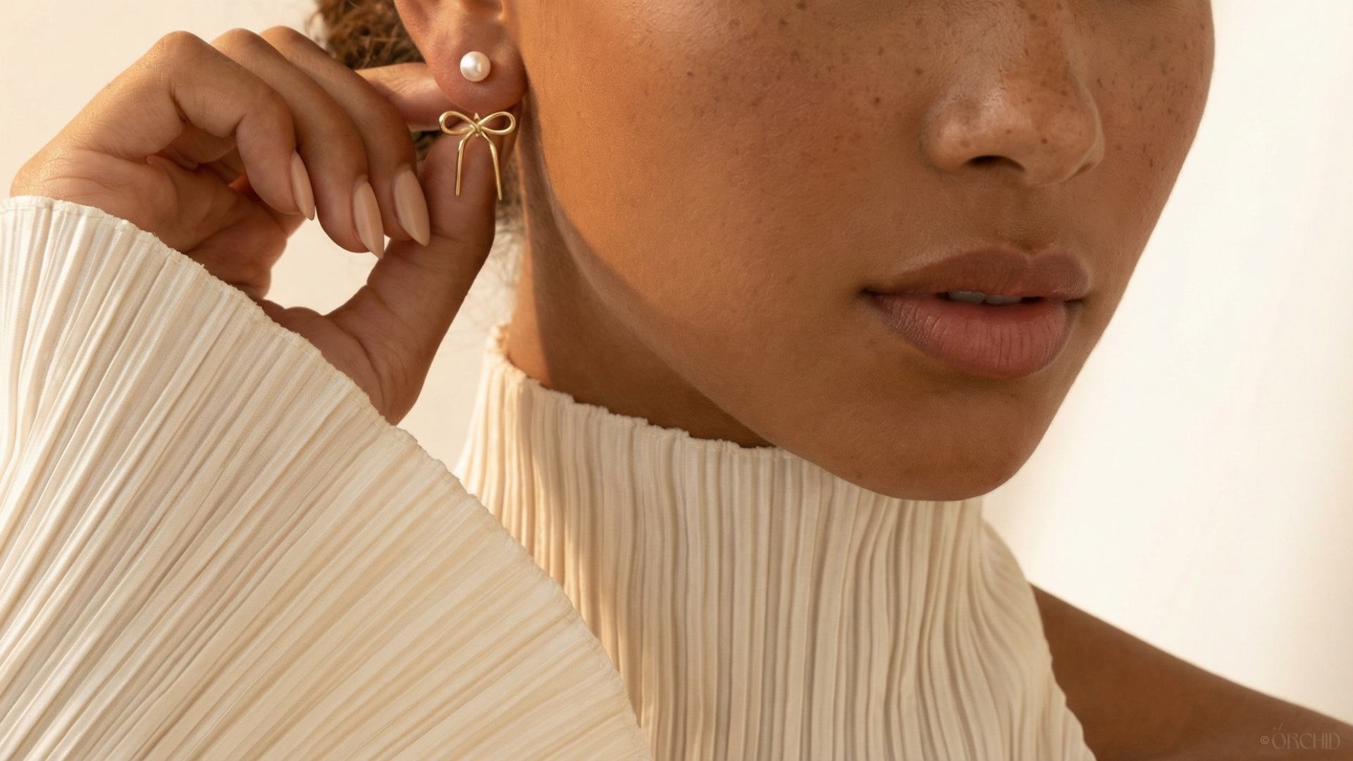 Close-up of a person wearing a delicate gold earring with a soft focus on the face.