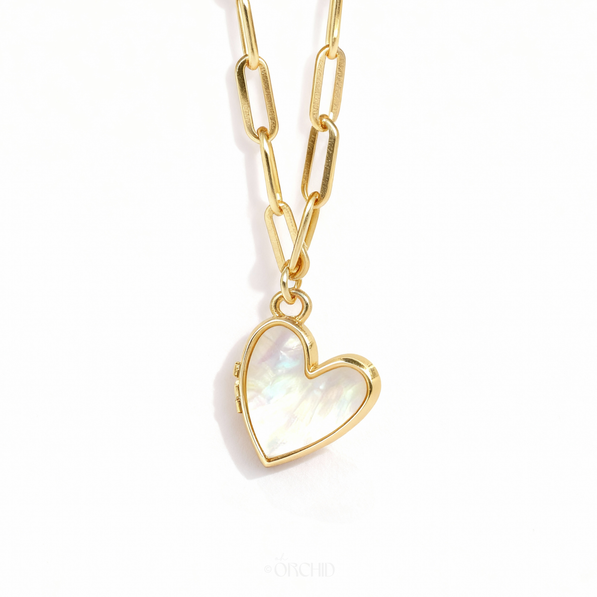 Gold mother-of-pearl heart locket necklace on white background
