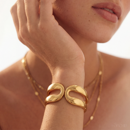 Gold bracelet on a wrist with a blurred background
