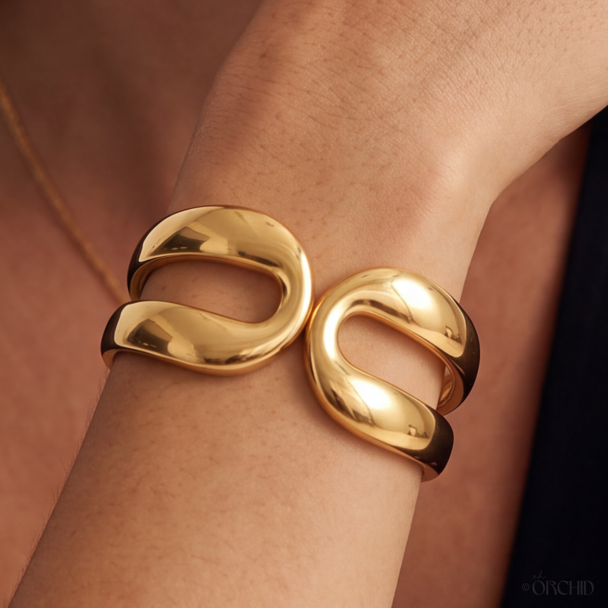 Gold bracelet on a wrist with a blurred background