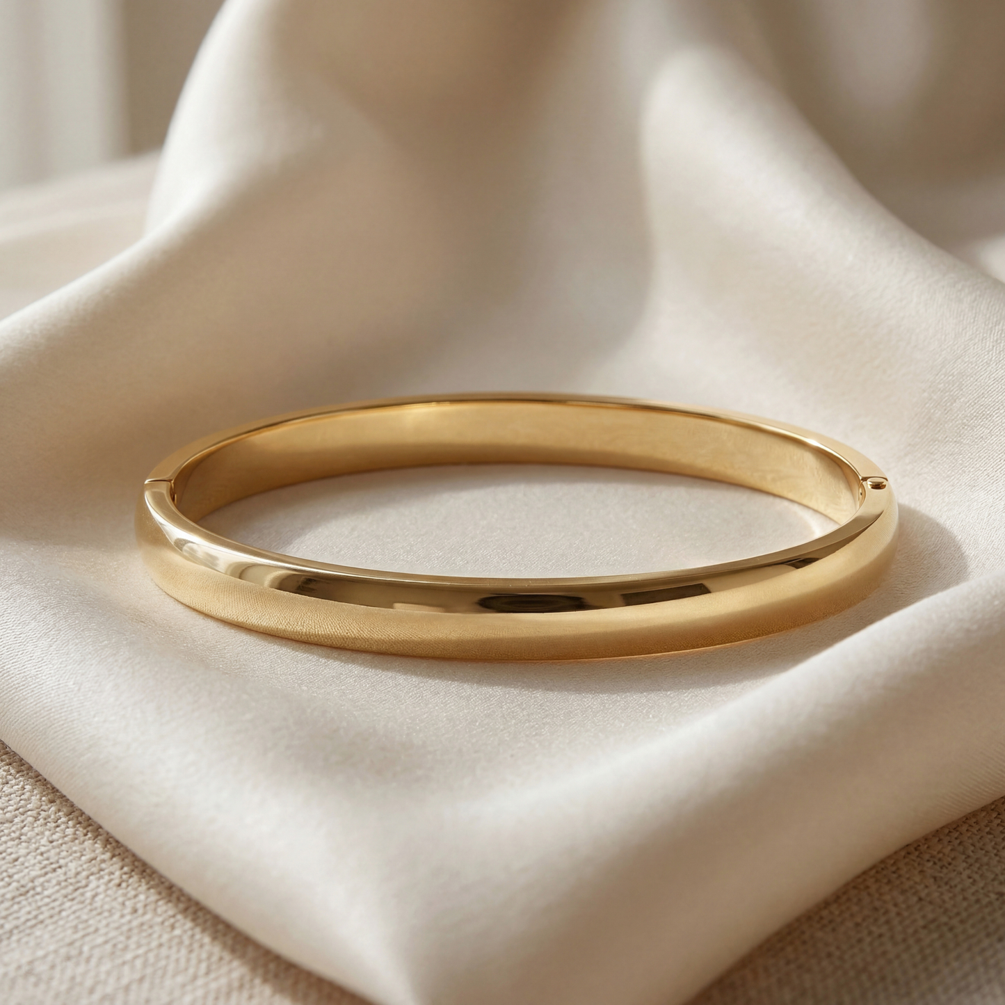 Gold bracelet on a beige fabric background