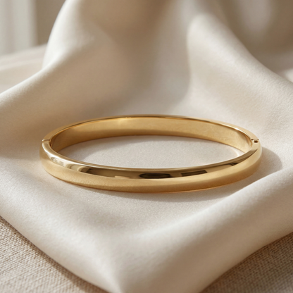 Gold bracelet on a beige fabric background