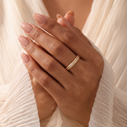 Hand wearing a gold ring with a soft beige background