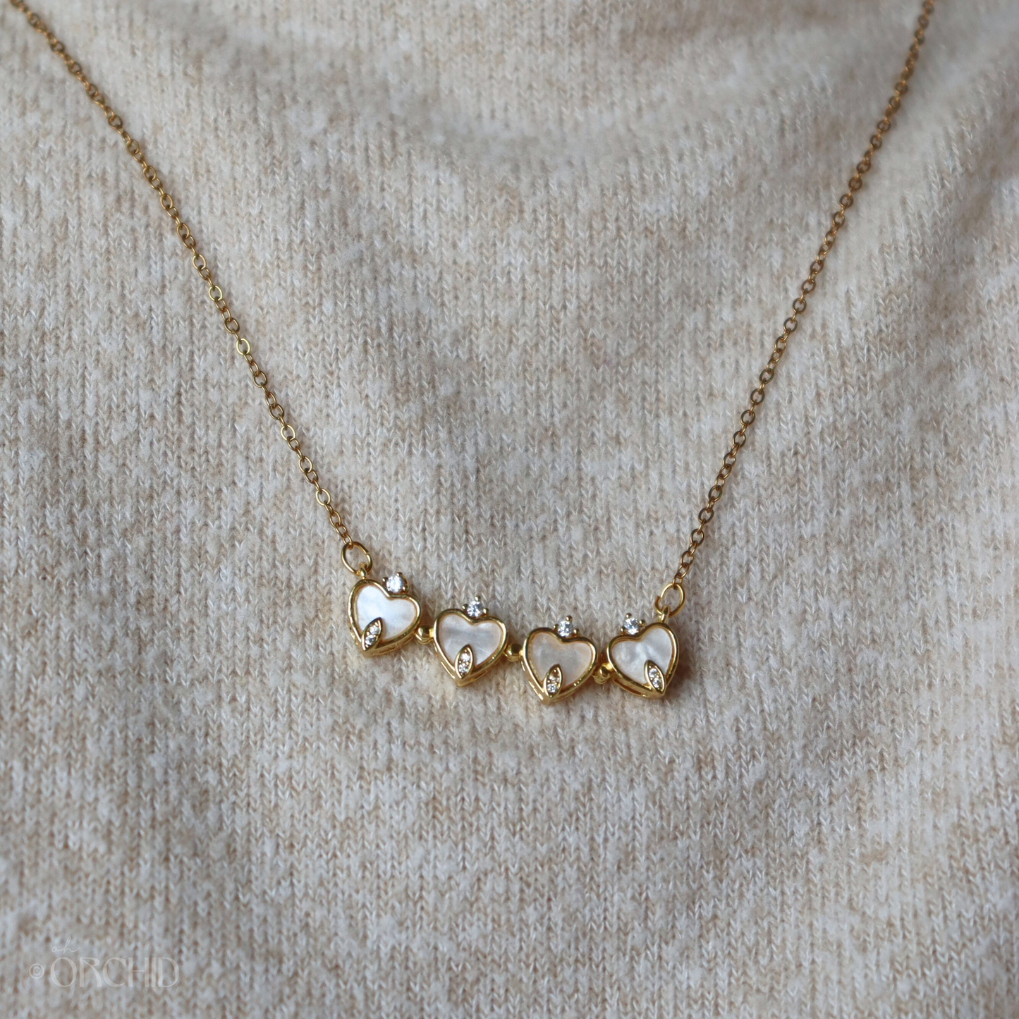 Necklace with heart-shaped pendants on a beige fabric background