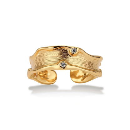Marisol Flowing Wave Ring, front view of the wavy textured gold-tone band with bezel zirconia accents
