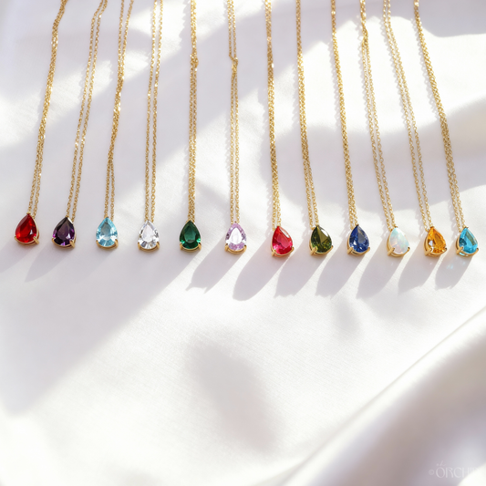 Gold necklaces with colorful gemstones on a white background
